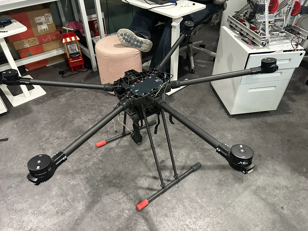 Side view of the drone showing its tall landing gear and red skid caps.